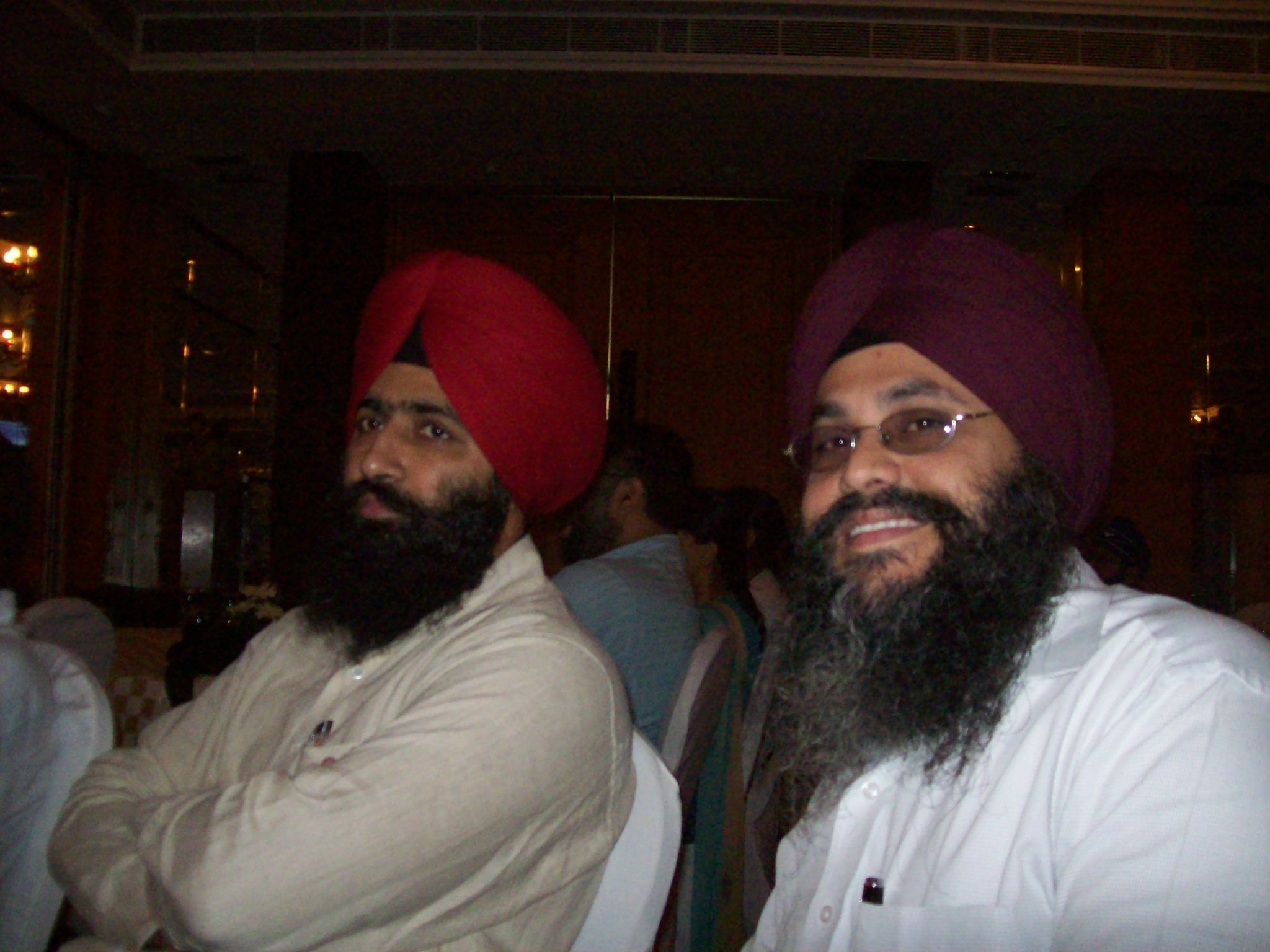 two people with long hair and turbans sitting next to each other