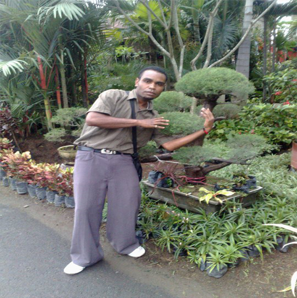 a man posing for a picture in front of a garden center