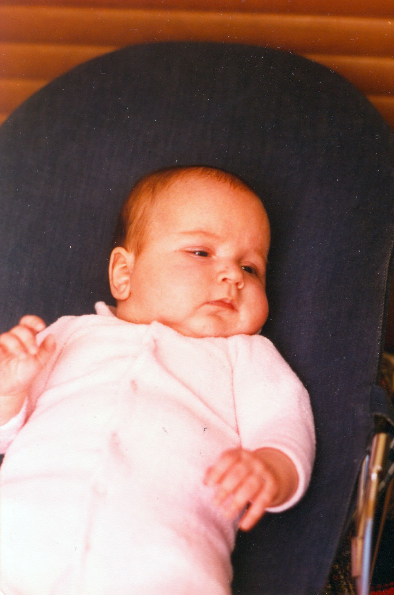 a baby is laying in a chair looking at the camera