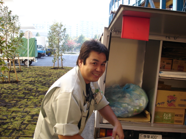 a man is smiling while leaning against a shelf