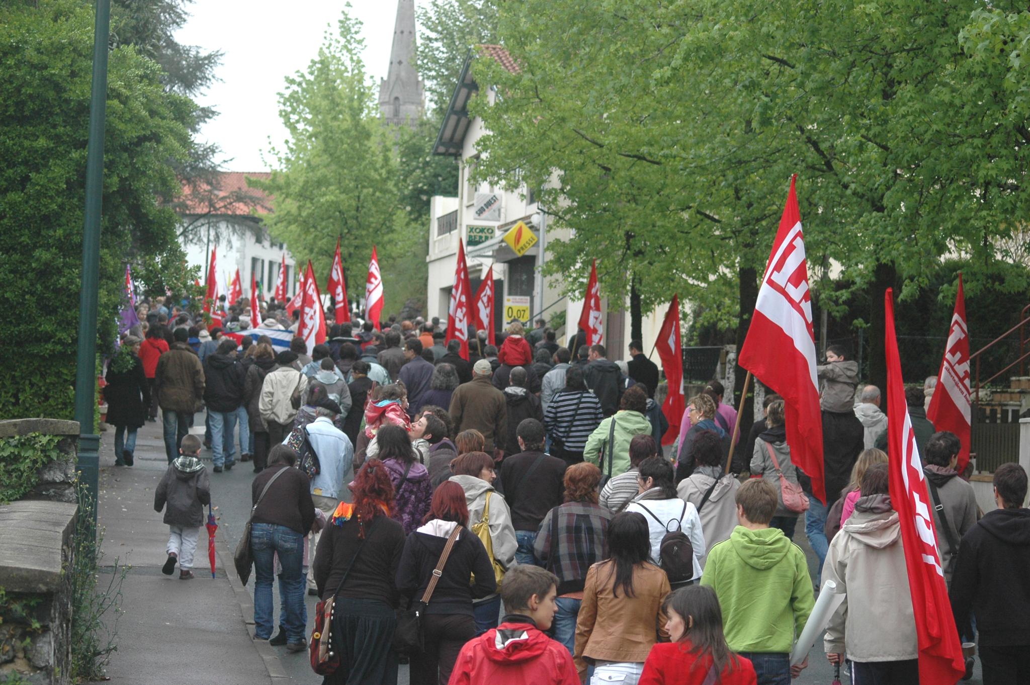 people marching down a busy street carrying flags