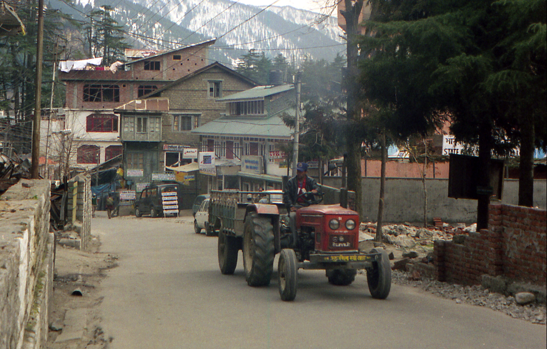 a tractor carrying several people through an abandoned village