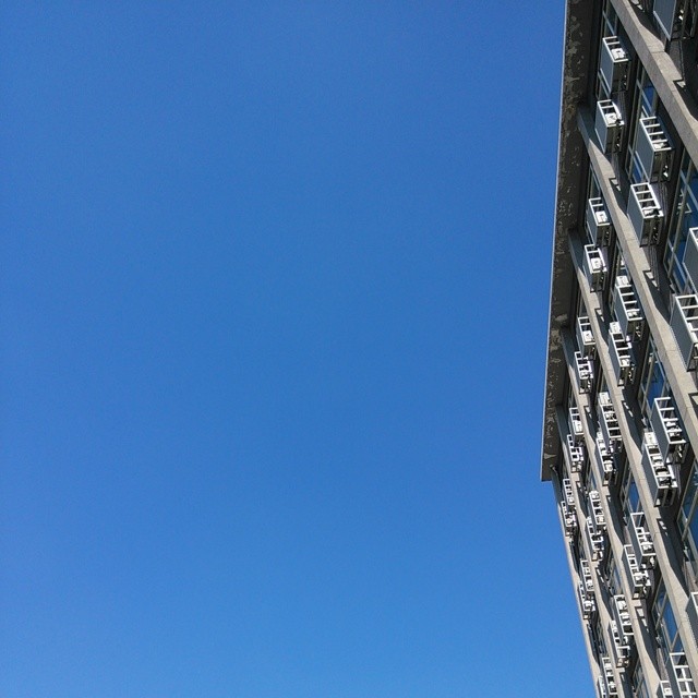 a building with balconies sitting outside and blue skies above
