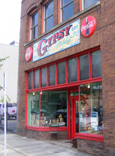 a store front with a giant window and a red wall