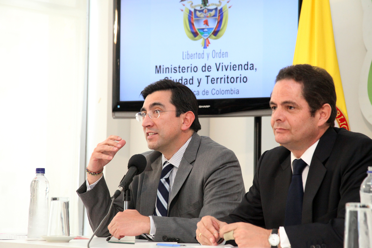 two men are sitting at a table with microphones