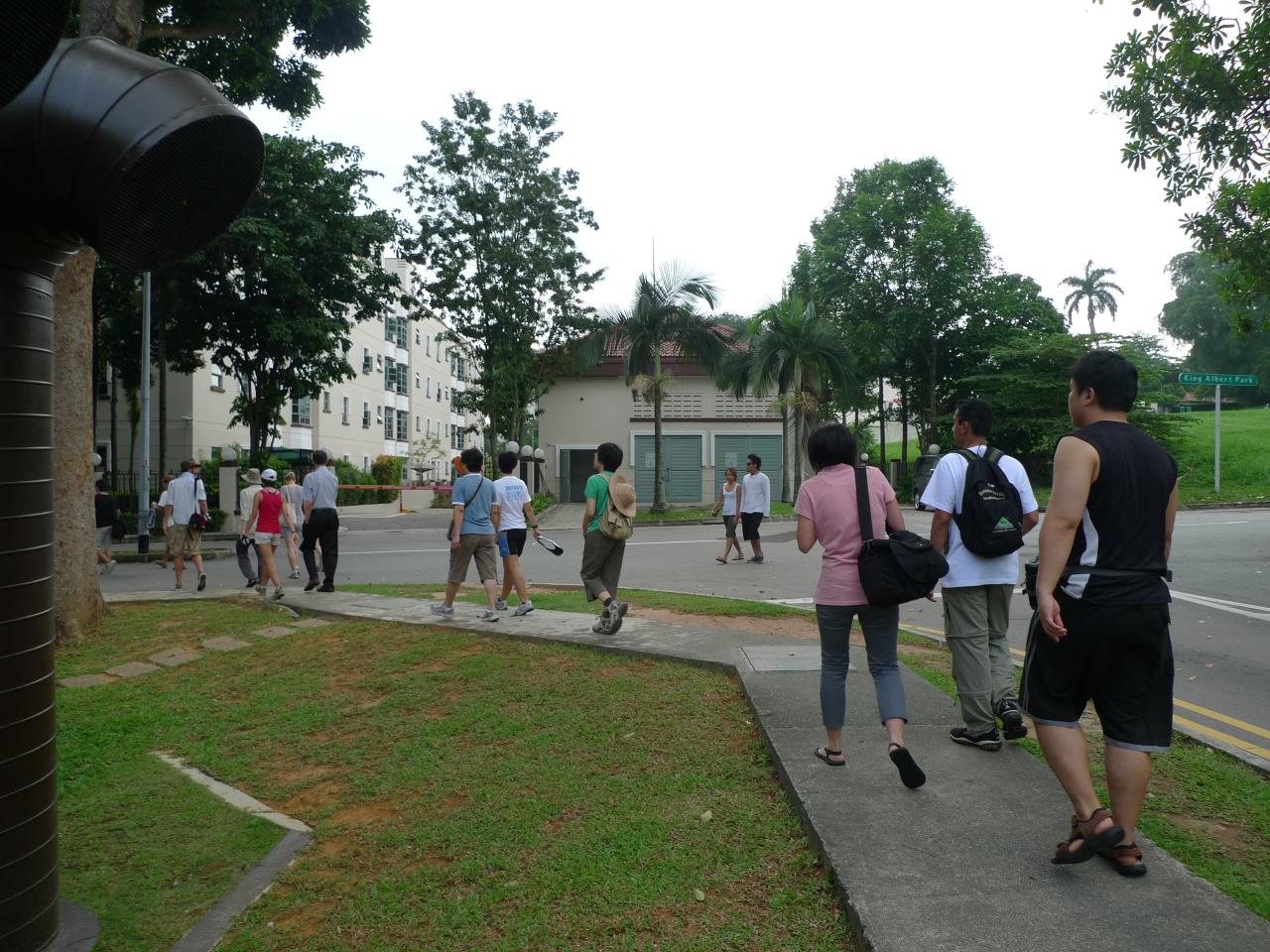 people in line walking down the sidewalk near a street