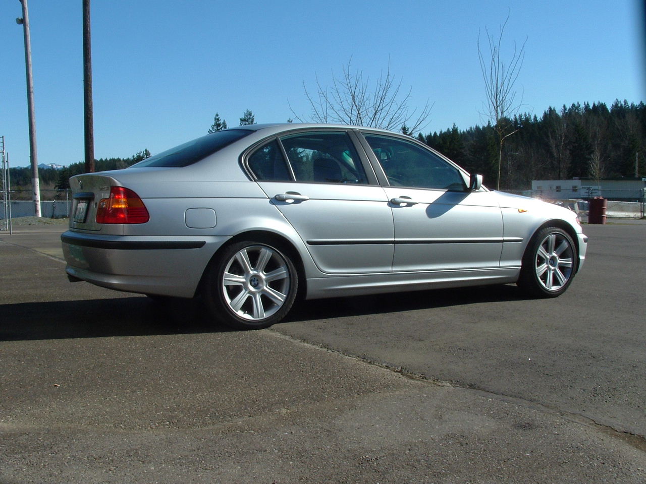 the rear end of a silver car parked in a parking lot