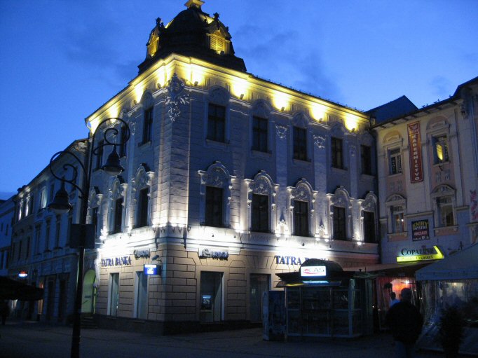 building with light displays at night near curb