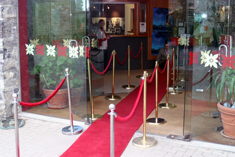 red carpet and barriers are lined up behind glass doors