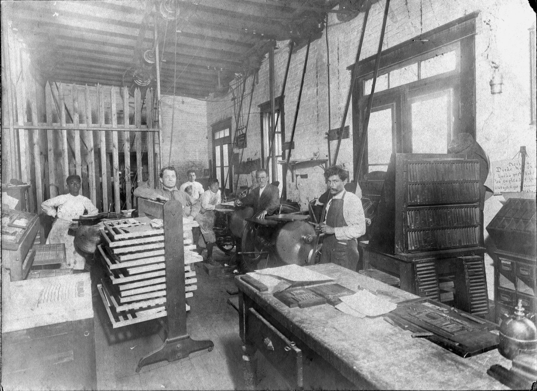 several people in a machine shop next to many tools