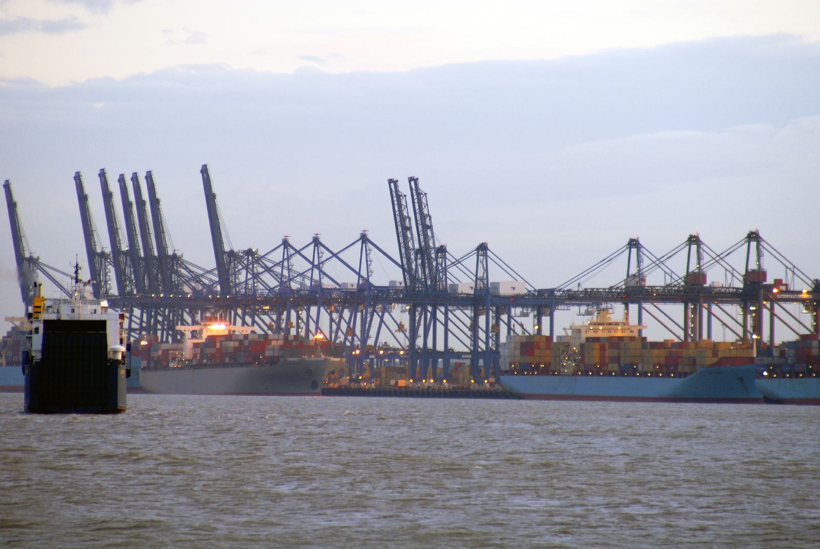 a large boat and some cranes are docked