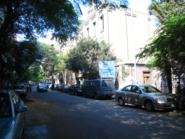 a city street is lined with cars and trees