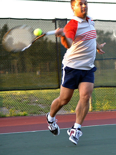 the tennis player is hitting a tennis ball with his racket