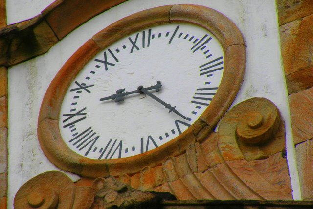 an ornate clock on the side of a building with roman numerals