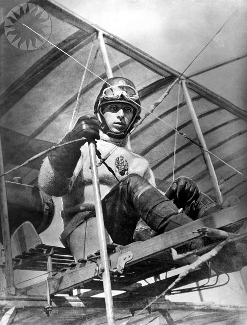 a man wearing a helmet on top of a plane