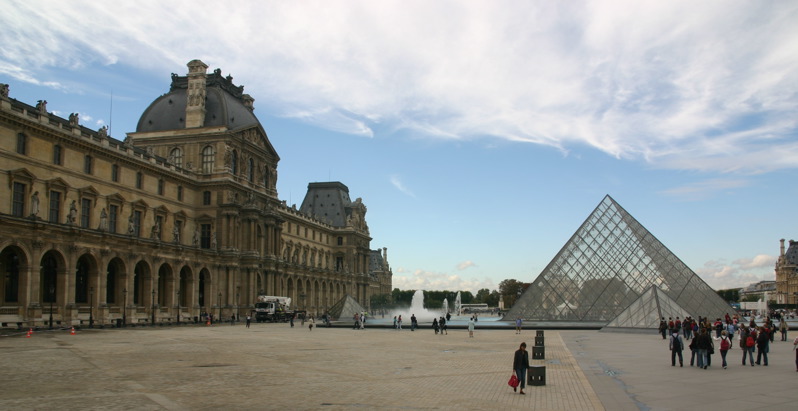 some people are standing outside in front of a pyramid