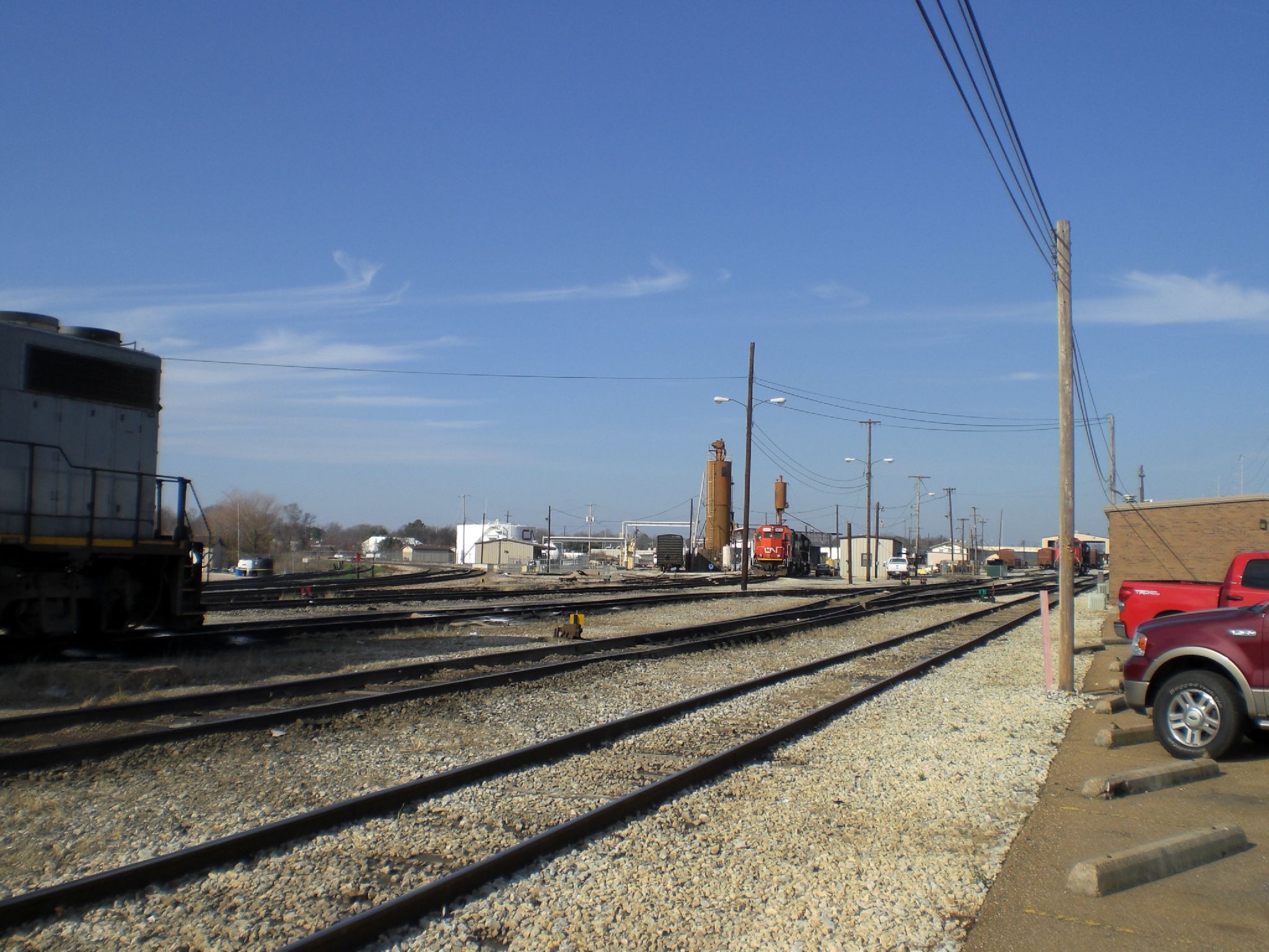 a red truck parked next to a train track