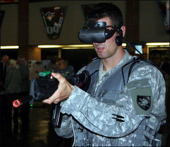 a soldier wearing ear muffs using an electronic device