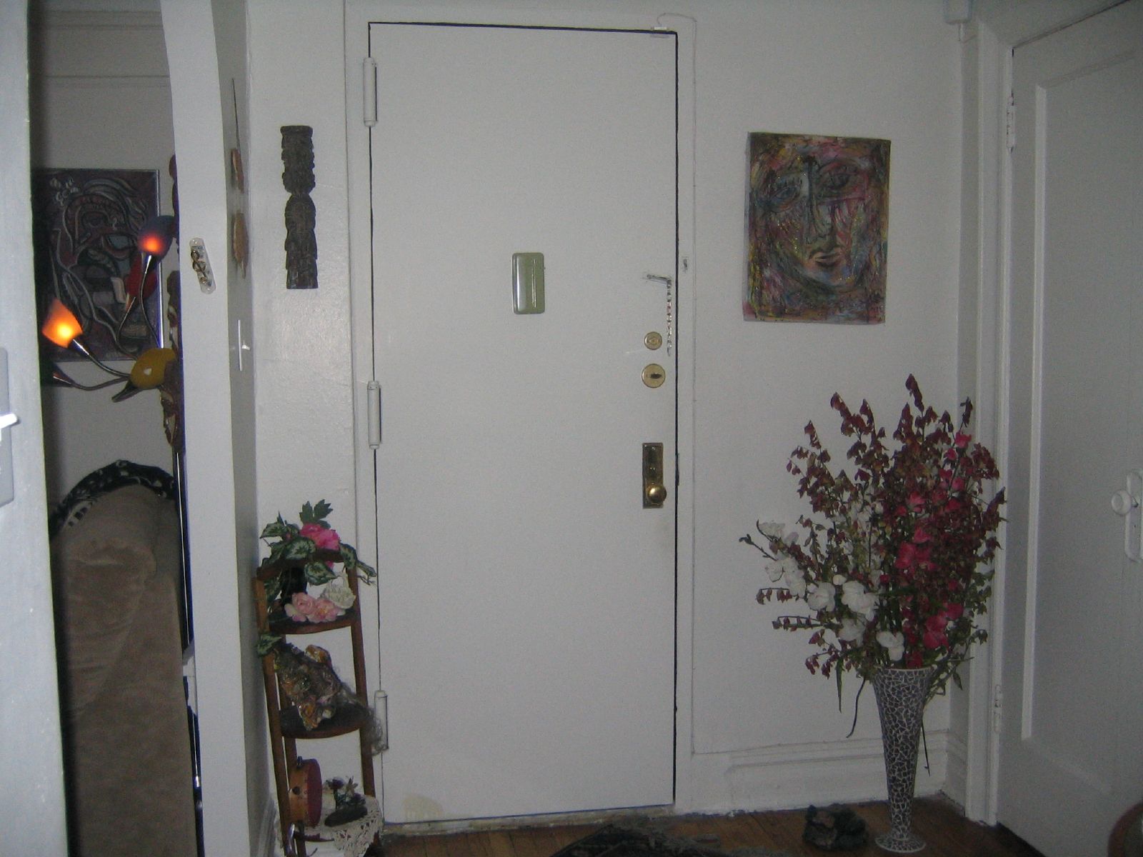 a hallway door is open to show flowers on the table