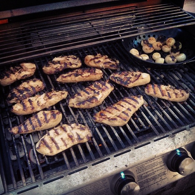 chicken cooking on a grill with a bunch of mushrooms
