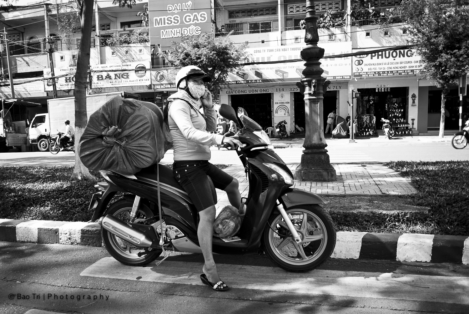 the woman is riding her motor scooter down the road