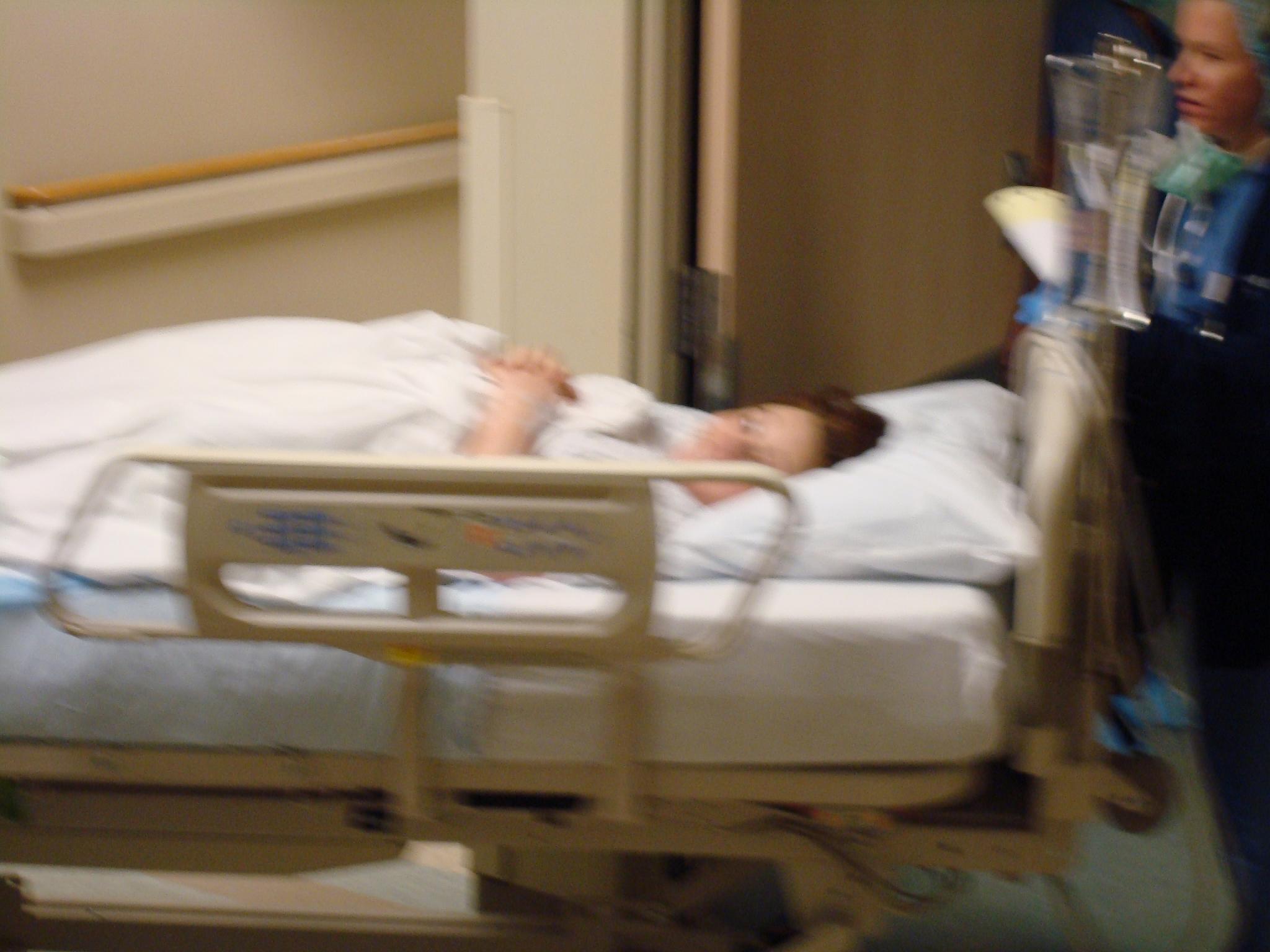 a woman laying on a bed inside of a hospital