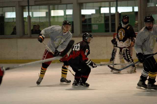 three boys on opposite teams playing ice hockey