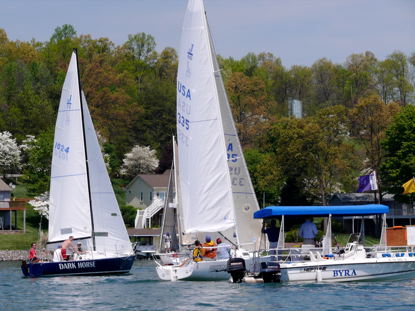 two sailboats are shown side by side near houses