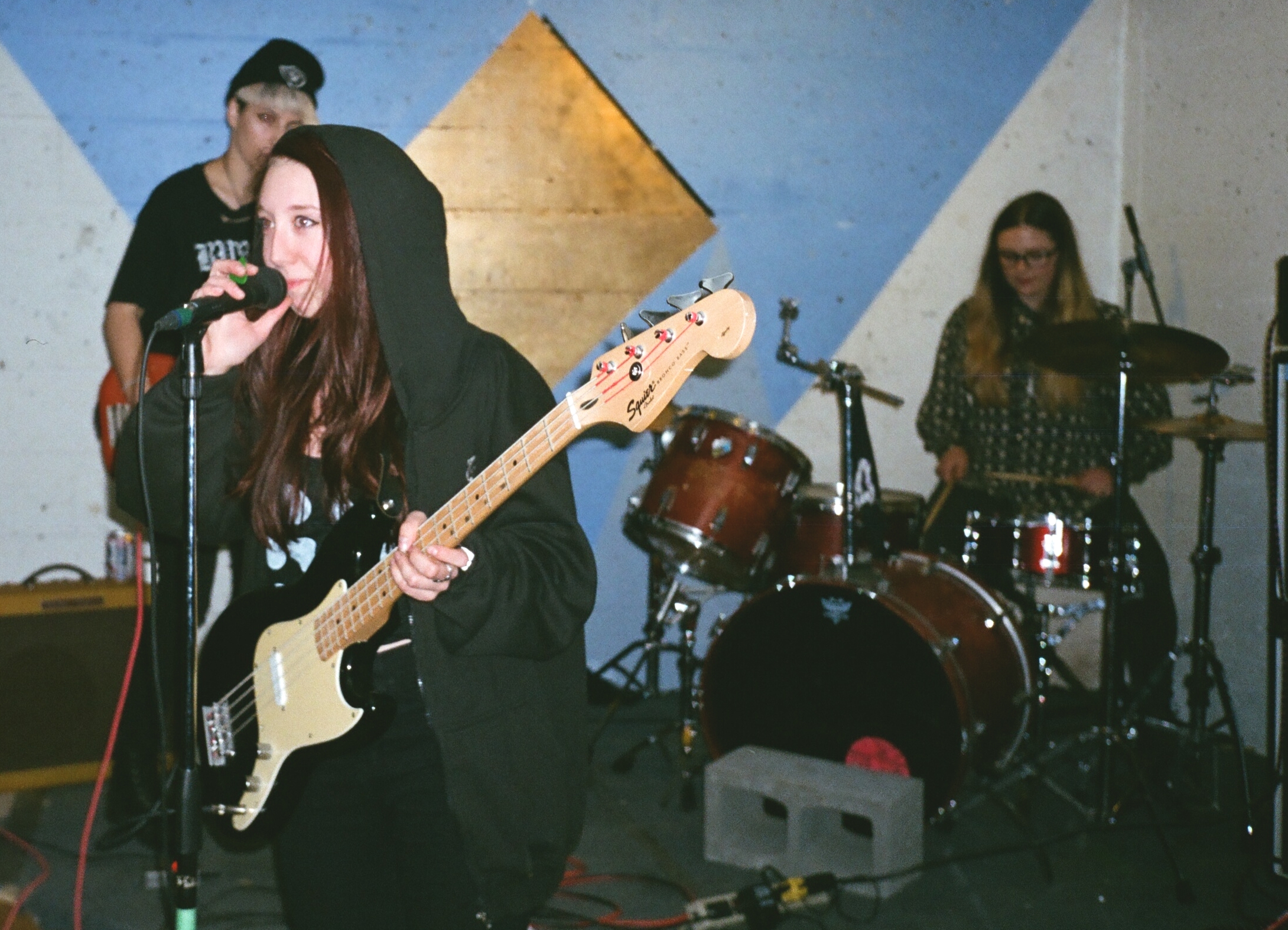 a man standing behind a woman with a guitar