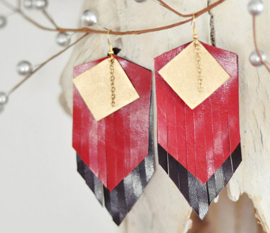 large gold - toned earrings on wooden plank