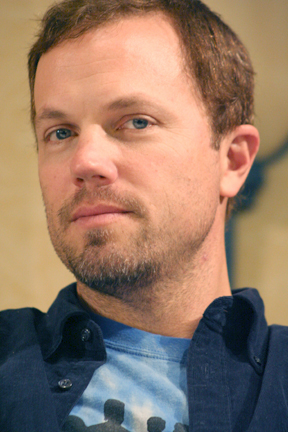 a man with blue eyes holding a cell phone