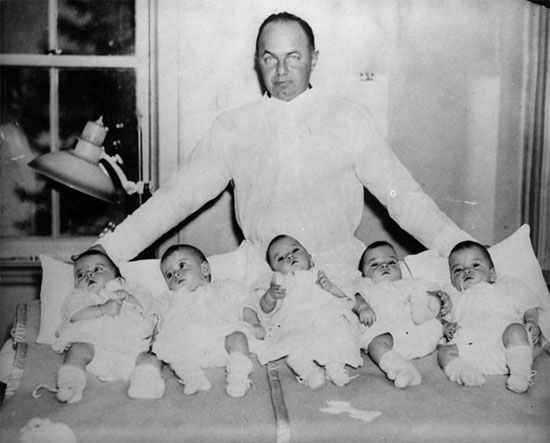 black and white po of a man with babies