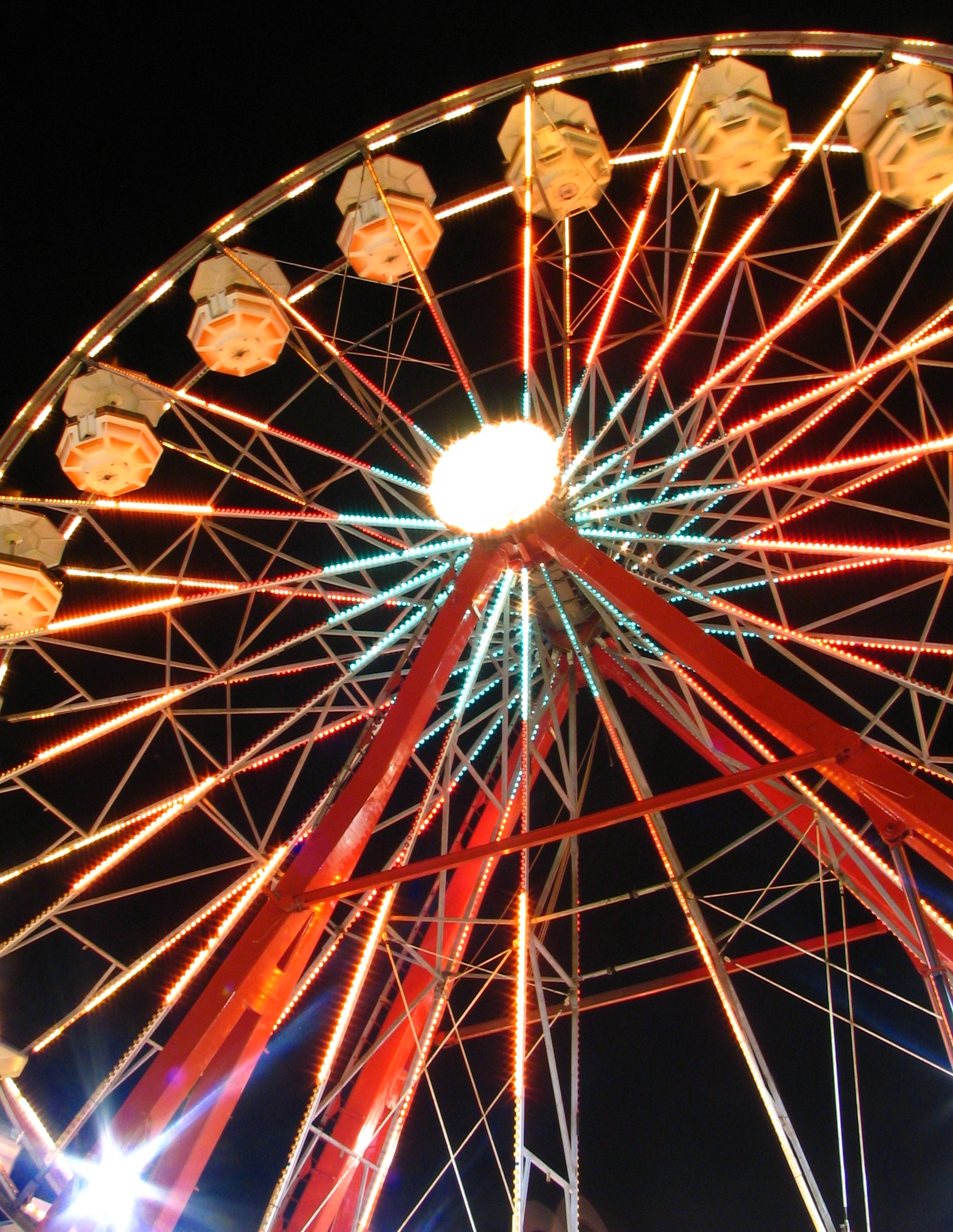 a ferris wheel at night with light up decorations