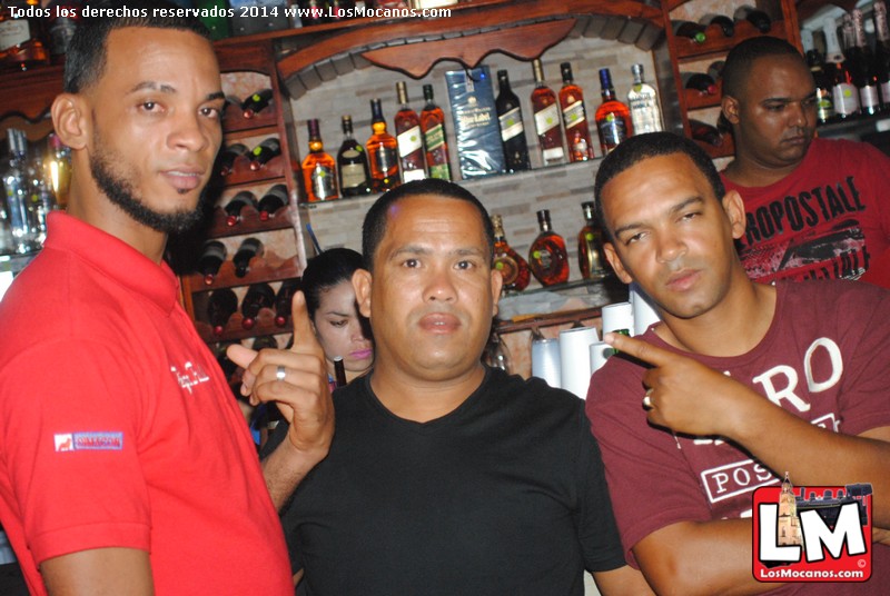 two guys are holding soing and standing next to a bar