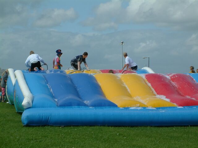 people standing on a bouncy house in an open field
