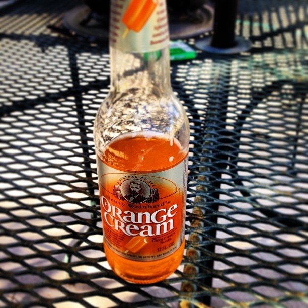 a bottle of orange cream sits on a wire table