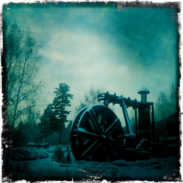 an old steam powered engine in the middle of a snow covered area