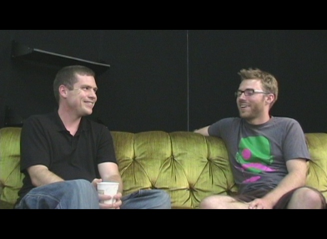 two men sitting on the couch while talking