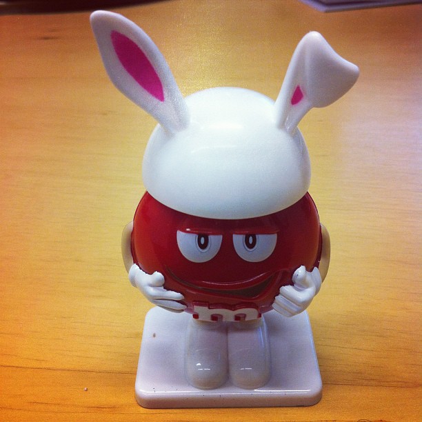 a white and red figurine is holding up an object