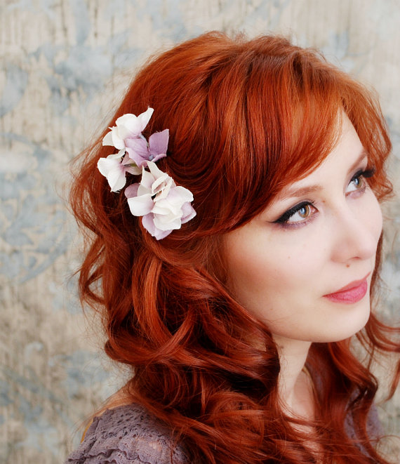 a woman with long red hair wearing flowers in her hair