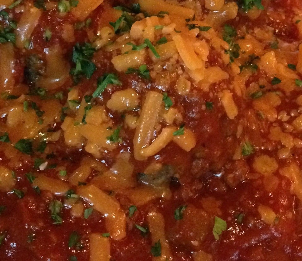 closeup of pasta sauce and fresh basil in pot