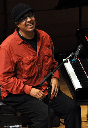 a man that is sitting at a piano smiling