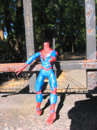 the spider man doll is posed in front of the fence