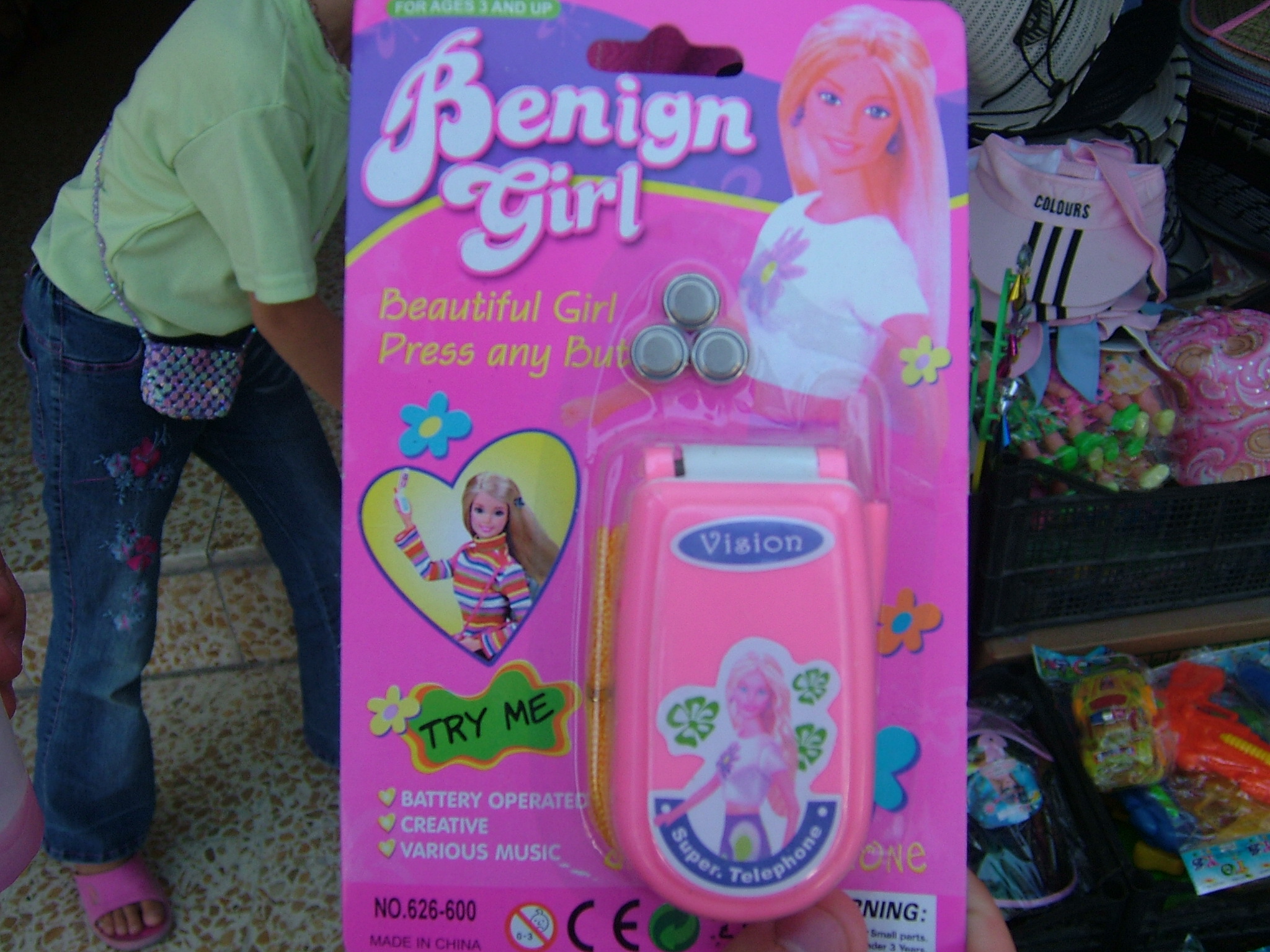 girl with pink wig and oned up barbie toy in front of store display