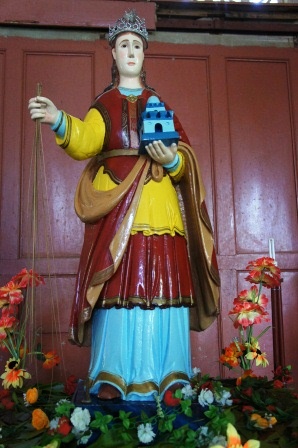 a statue of a priest holding a blue house