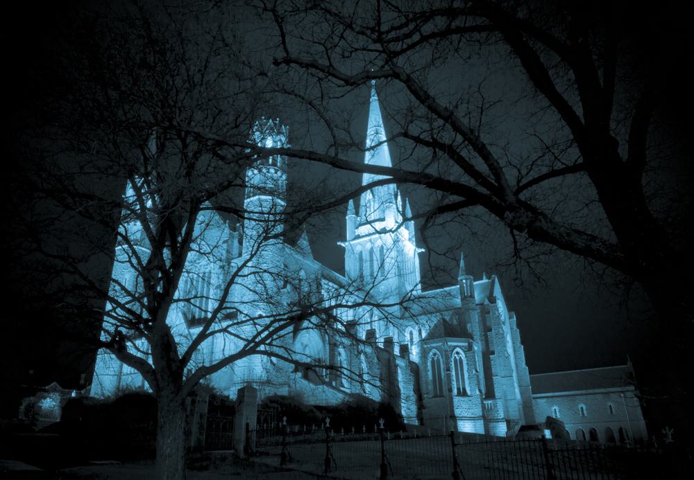 lit church with graveyard on cemetery in front