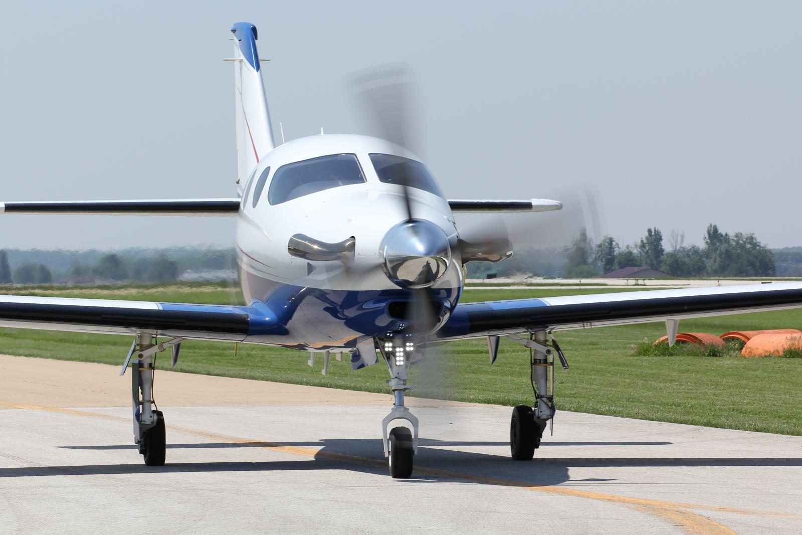 the small blue and white airplane is sitting on the runway