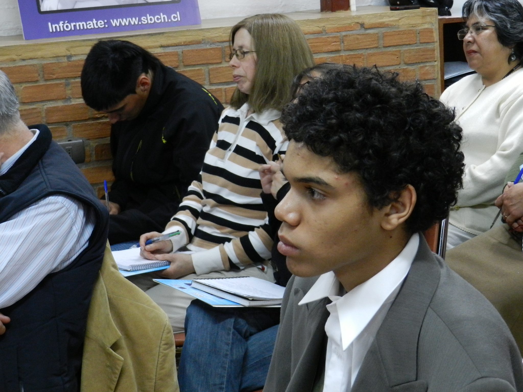 group of people sitting in a row in the waiting area