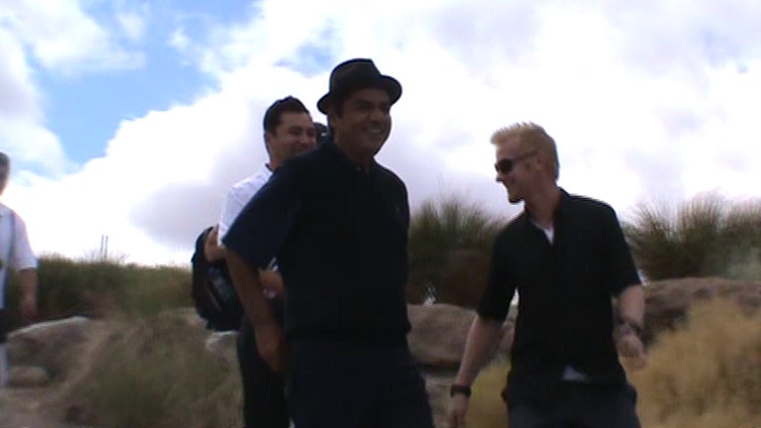 a group of men in sunglasses walking along side a mountain