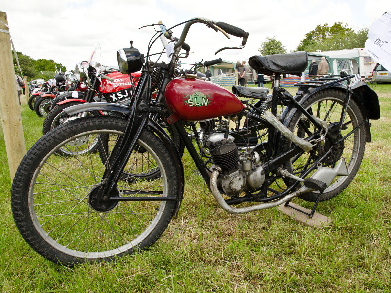 some motor cycles parked next to each other on the grass